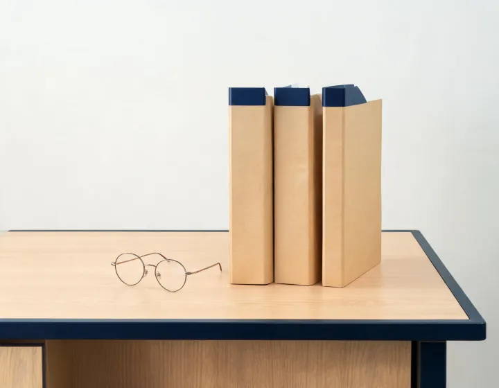 Round glasses men brief beside factory quote folders